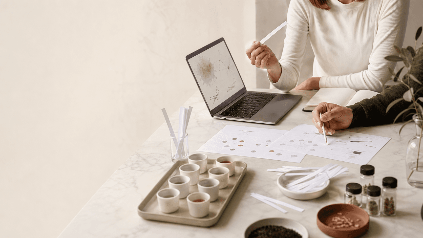 Sensory research collaboration workspace with sample cups, data charts, and analysis tools
